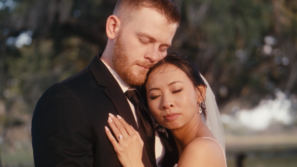 Bride and groom, eyes closed, embracing